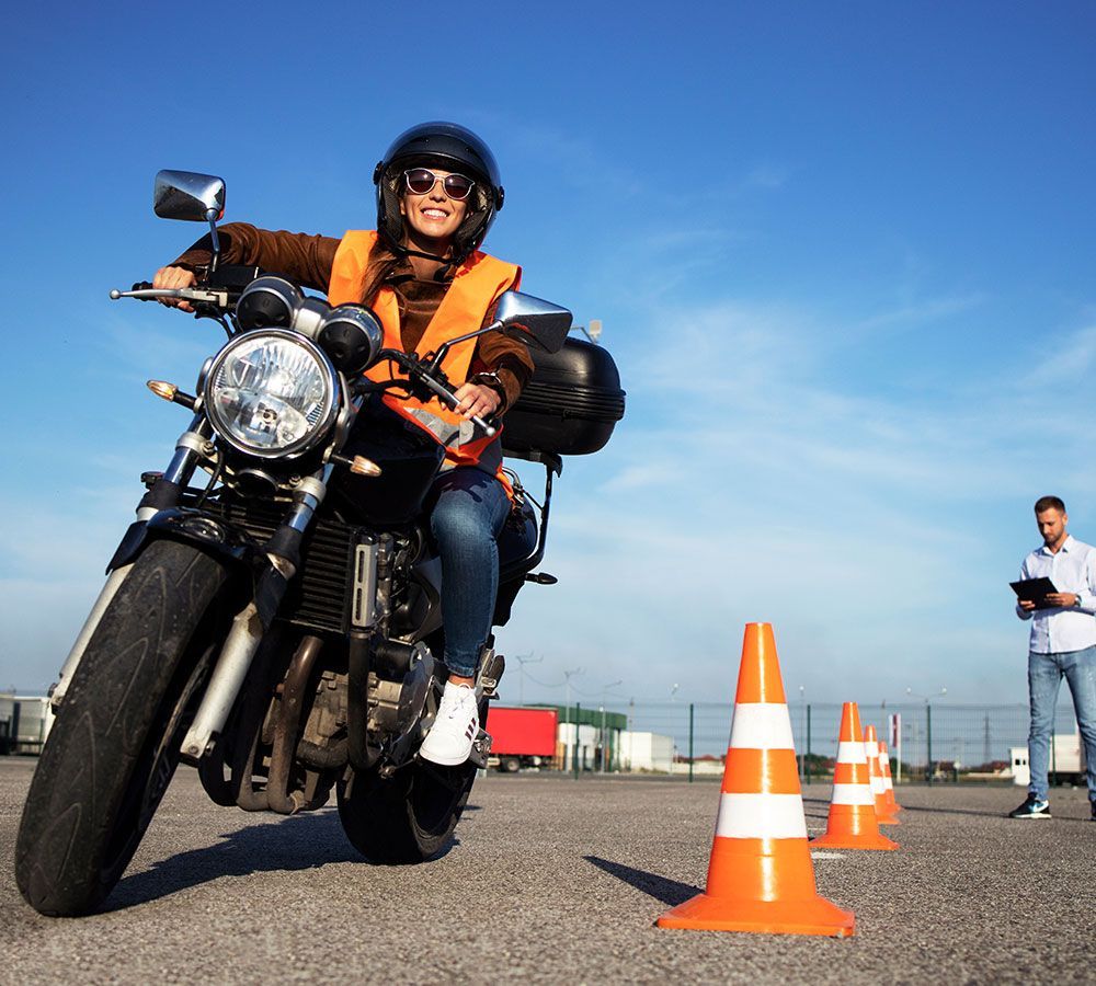 Junge Frau auf einem Motorrad beim einem Sicherheitstraining